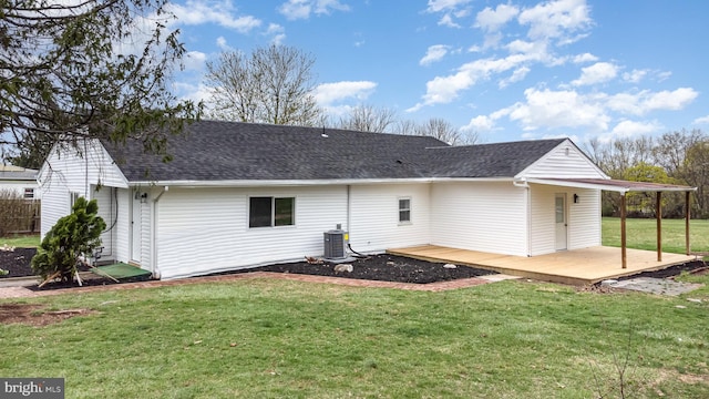 back of house featuring a yard, central AC unit, a deck, and roof with shingles