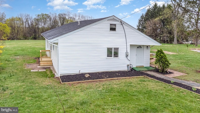 exterior space featuring a yard and a shingled roof