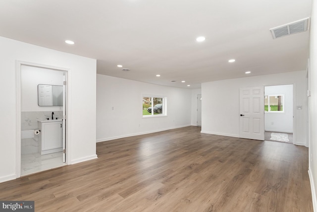 unfurnished living room with recessed lighting, visible vents, baseboards, and wood finished floors