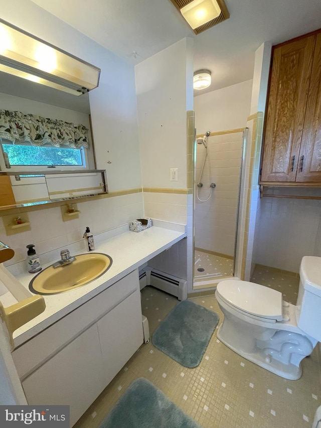 full bathroom with toilet, a baseboard heating unit, a shower stall, and vanity