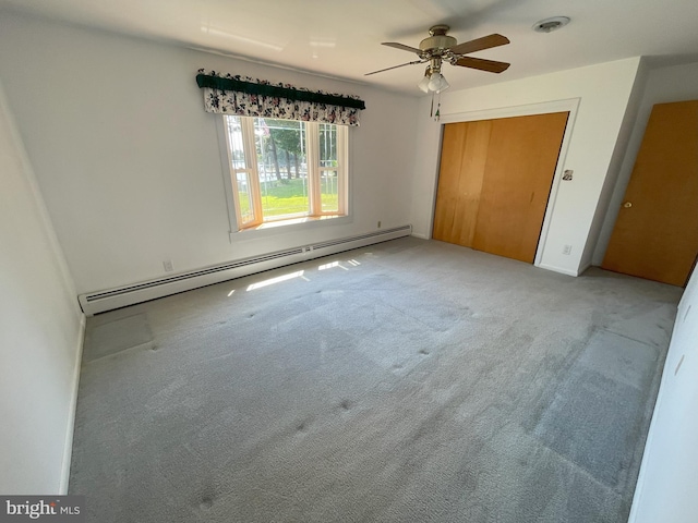 unfurnished bedroom featuring carpet flooring, baseboard heating, a closet, and baseboards