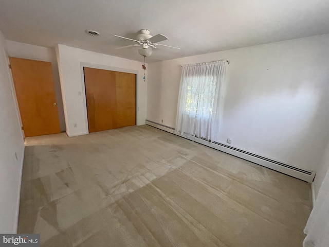 unfurnished bedroom with visible vents, a closet, ceiling fan, baseboard heating, and light carpet