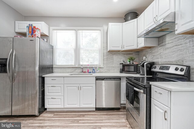 417 E Main St, Millville, NJ 08332 - kitchen with light countertops, white cabinets, under cabinet range hood, stainless steel appliances, and a sink