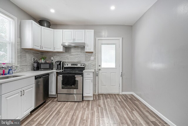 417 E Main St, Millville, NJ 08332 - kitchen featuring stainless steel appliances, under cabinet range hood, light countertops, and a wealth of natural light
