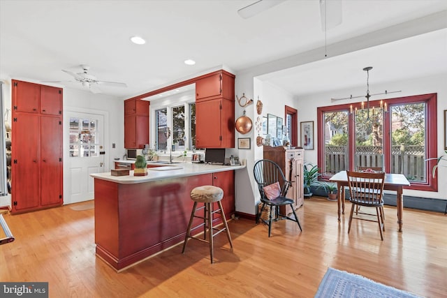 kitchen with recessed lighting, a peninsula, light wood-style flooring, light countertops, and a ceiling fan