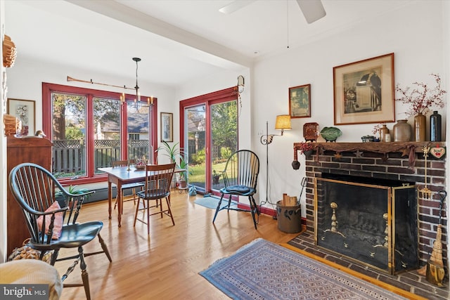 sitting room featuring wood finished floors, ceiling fan, and a fireplace