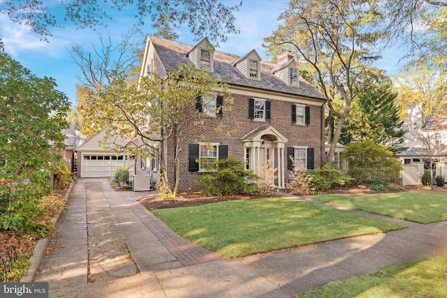 view of front of property featuring a garage, brick siding, fence, and a front lawn