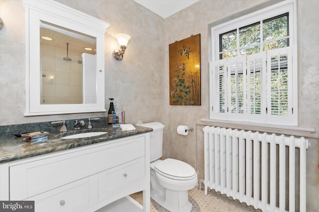 full bath with toilet, vanity, a tile shower, and radiator