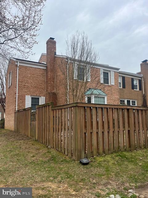 474 Colonial Ridge Ln, Arnold, MD 21012 - back of property featuring a chimney, brick siding, and fence