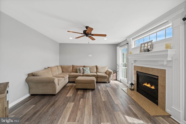 living area with recessed lighting, a high end fireplace, ceiling fan, and wood finished floors