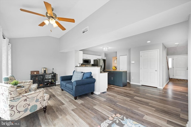 living room featuring ceiling fan, visible vents, wood finished floors, lofted ceiling, and baseboards
