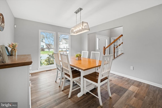 dining area with visible vents, baseboards, and wood finished floors
