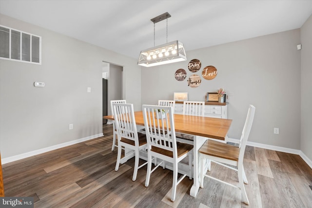 dining room featuring wood finished floors, baseboards, and visible vents