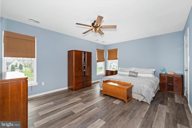 bedroom featuring wood finished floors, ceiling fan, baseboards, and visible vents