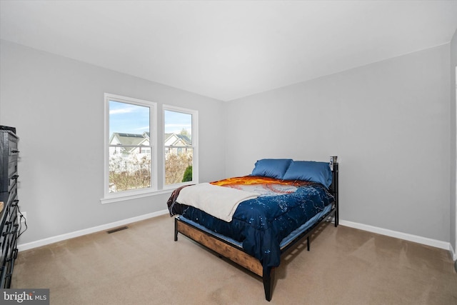carpeted bedroom with baseboards and visible vents