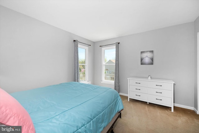bedroom featuring baseboards and light carpet