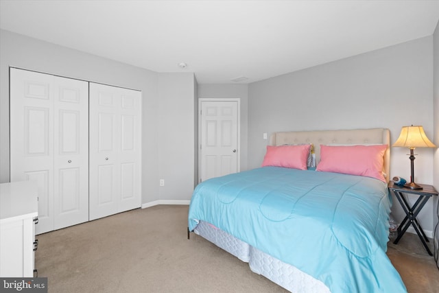 carpeted bedroom with a closet and baseboards