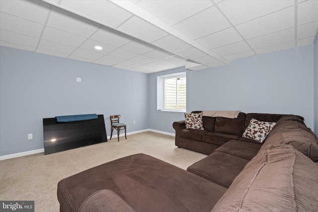 living room featuring carpet floors, baseboards, and a paneled ceiling