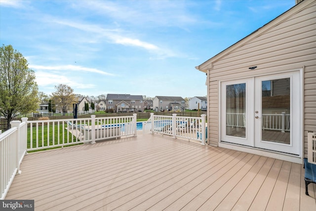wooden deck featuring a yard, french doors, fence, and a residential view