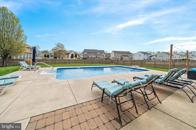 view of swimming pool featuring a patio, a fenced backyard, a fenced in pool, and a residential view