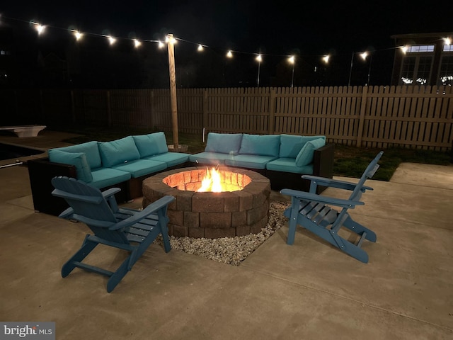 patio at twilight featuring an outdoor living space with a fire pit and a fenced backyard
