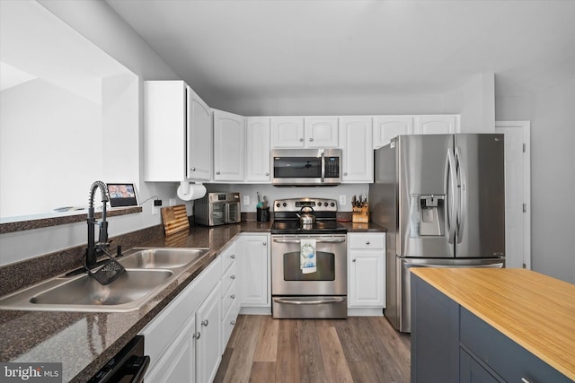 kitchen featuring white cabinetry, a sink, and appliances with stainless steel finishes