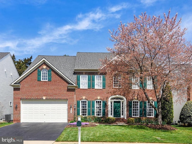 14128 Snickersville Dr, Gainesville, VA 20155 - colonial inspired home with asphalt driveway, a front yard, brick siding, a garage, and a shingled roof