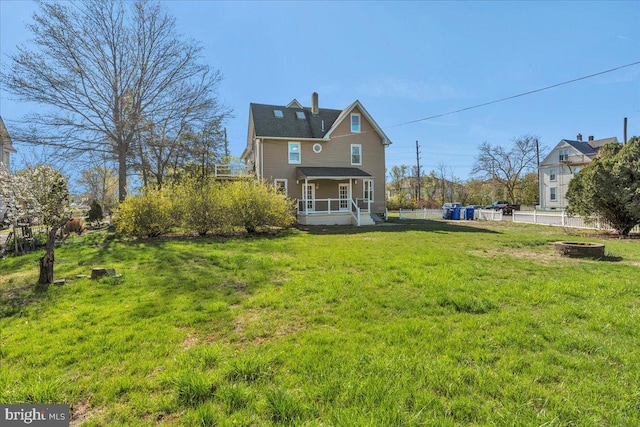 700 Pennsylvania Ave, Delanco, NJ 08075 - back of property featuring a chimney, a lawn, covered porch, a fire pit, and fence