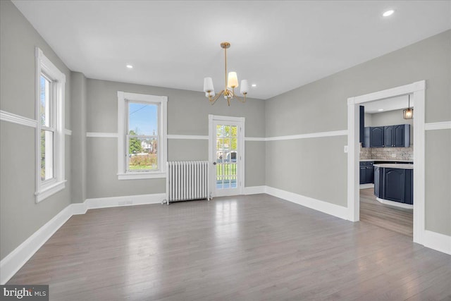 700 Pennsylvania Ave, Delanco, NJ 08075 - unfurnished dining area with baseboards, wood finished floors, a notable chandelier, and radiator