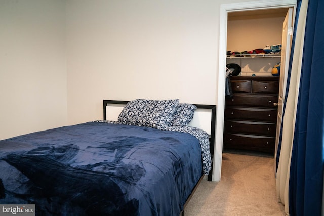 carpeted bedroom with a walk in closet