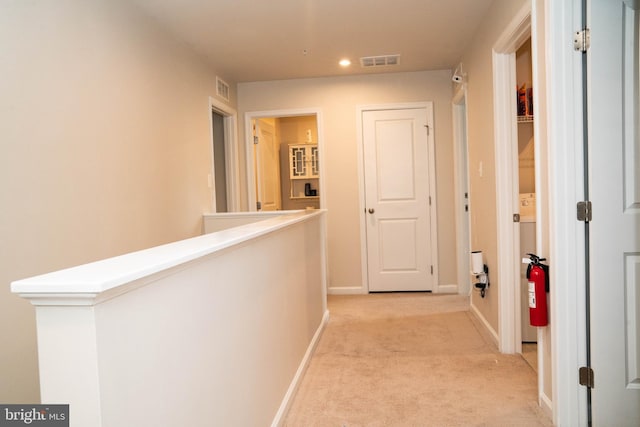 hallway with baseboards, visible vents, light colored carpet, and recessed lighting