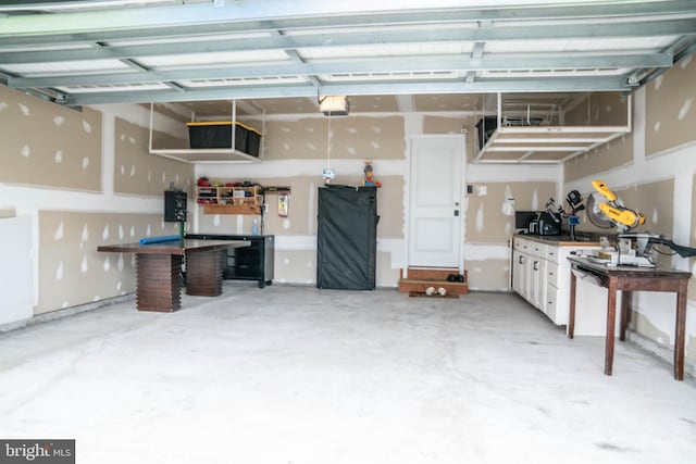 garage with a garage door opener and a workshop area