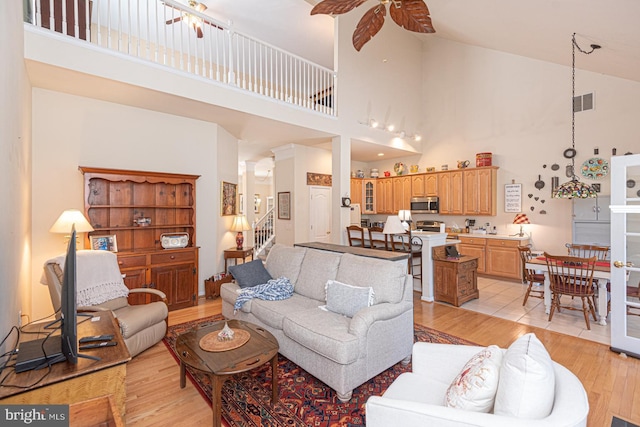 25 Easton Ave, Ocean Pines, MD 21811 - living room featuring stairway, a ceiling fan, light wood-style floors, visible vents, and high vaulted ceiling