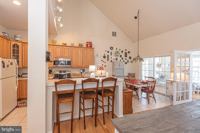 25 Easton Ave, Ocean Pines, MD 21811 - kitchen with high vaulted ceiling, light countertops, visible vents, a breakfast bar area, and stainless steel appliances