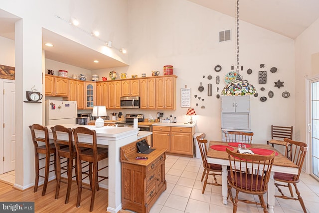 25 Easton Ave, Ocean Pines, MD 21811 - kitchen with high vaulted ceiling, glass insert cabinets, a kitchen breakfast bar, visible vents, and appliances with stainless steel finishes