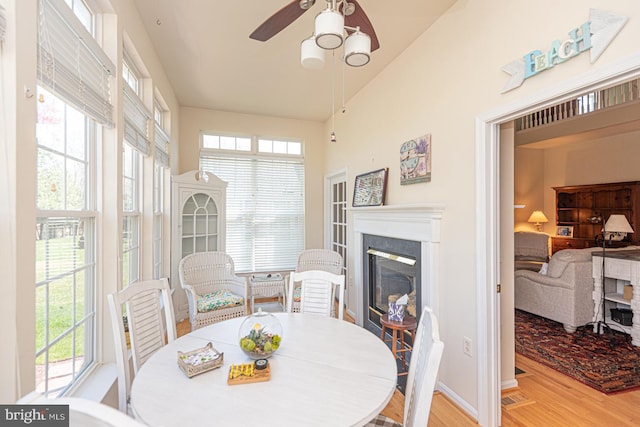 25 Easton Ave, Ocean Pines, MD 21811 - dining room featuring a wealth of natural light, a glass covered fireplace, wood finished floors, and ceiling fan