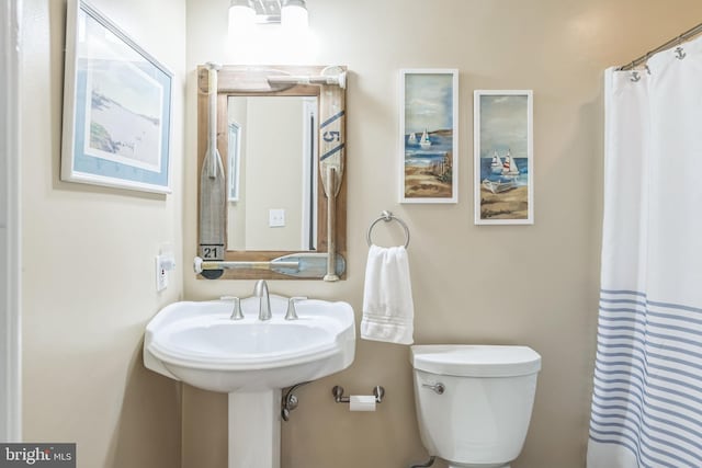 bathroom with toilet and curtained shower
