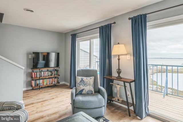 living area featuring visible vents, baseboards, and wood finished floors