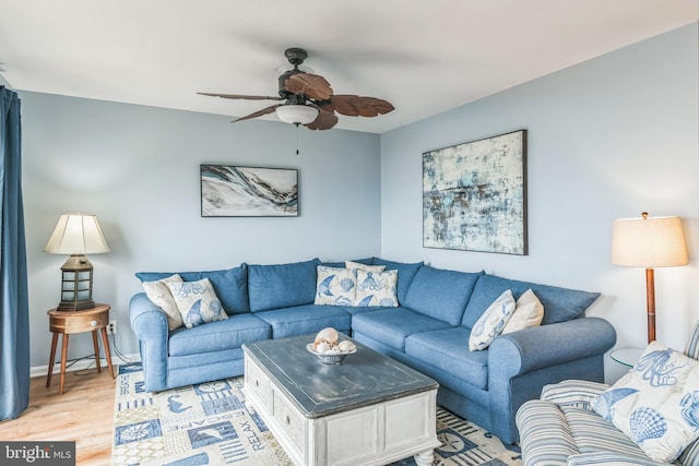 living room featuring light wood-type flooring and a ceiling fan