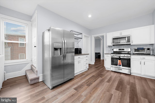 kitchen featuring white cabinetry, appliances with stainless steel finishes, and light wood-style floors