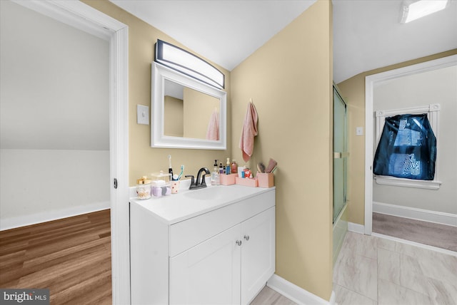 full bath with baseboards, vanity, shower / bath combination with glass door, and lofted ceiling