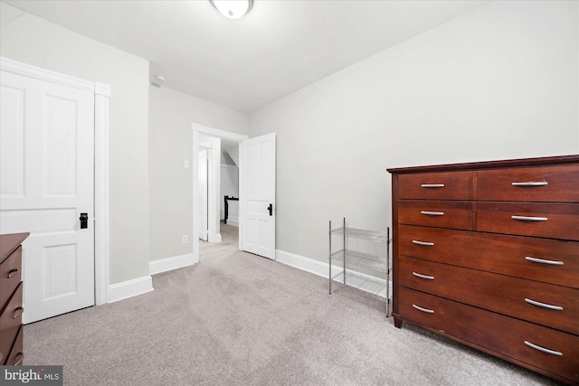 bedroom featuring light carpet and baseboards