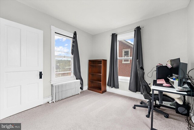office area with carpet floors, baseboards, radiator, and plenty of natural light