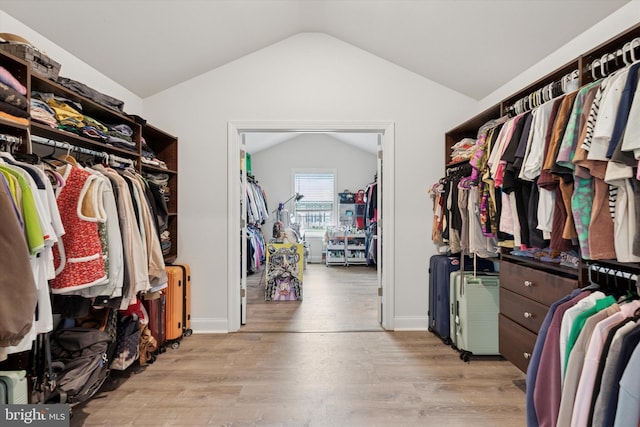 spacious closet with light wood-style flooring and vaulted ceiling