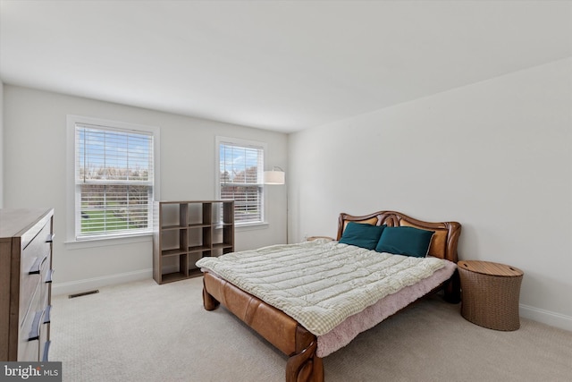 carpeted bedroom featuring visible vents and baseboards