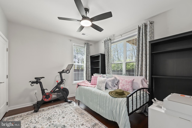 bedroom featuring a ceiling fan, baseboards, visible vents, and wood finished floors