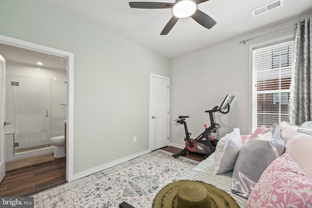 bedroom with visible vents, wood finished floors, baseboards, ensuite bathroom, and ceiling fan