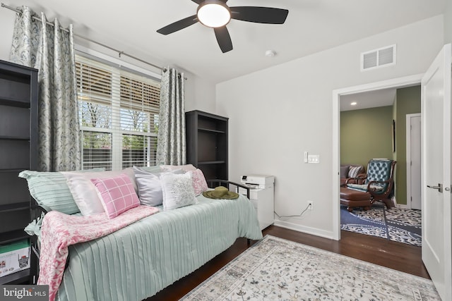 living area with visible vents, baseboards, ceiling fan, and wood finished floors