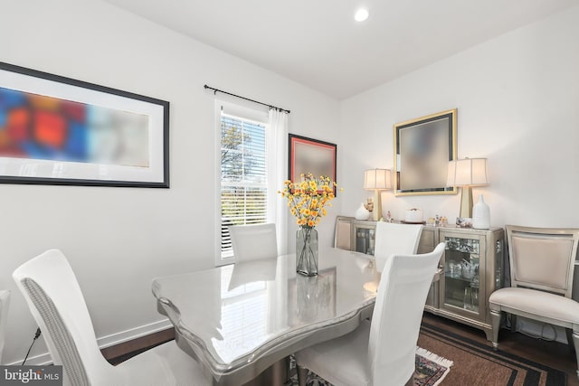 dining space with baseboards and wood finished floors