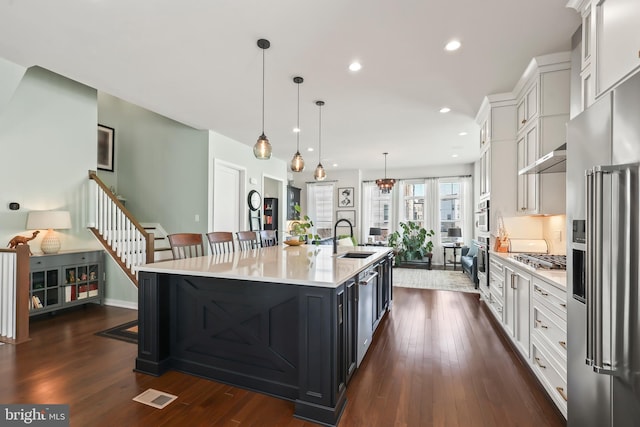 kitchen with white cabinets, a sink, light countertops, stainless steel appliances, and visible vents